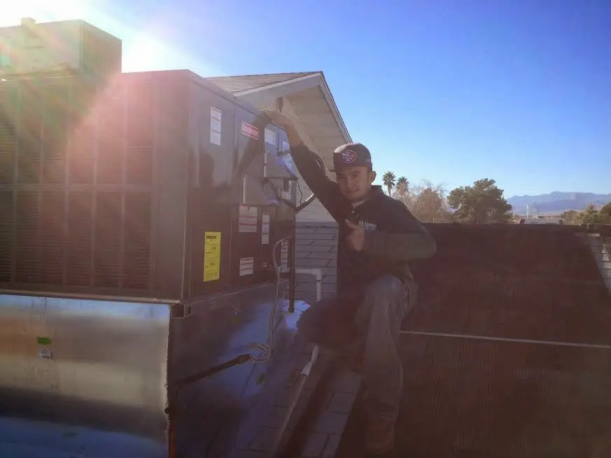 HVAC technician performing Air Duct Repair on a rooftop unit in Rainbow City